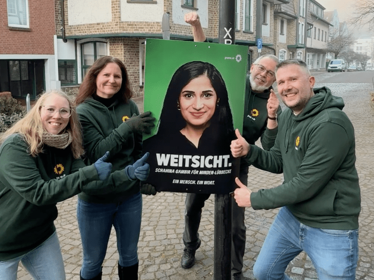 Sandra Kiskemper, Stephanie Moore, Jörg Böhm und Sebastian Ehmke halten ein Wahlplakat von Schahina Gambir hoch